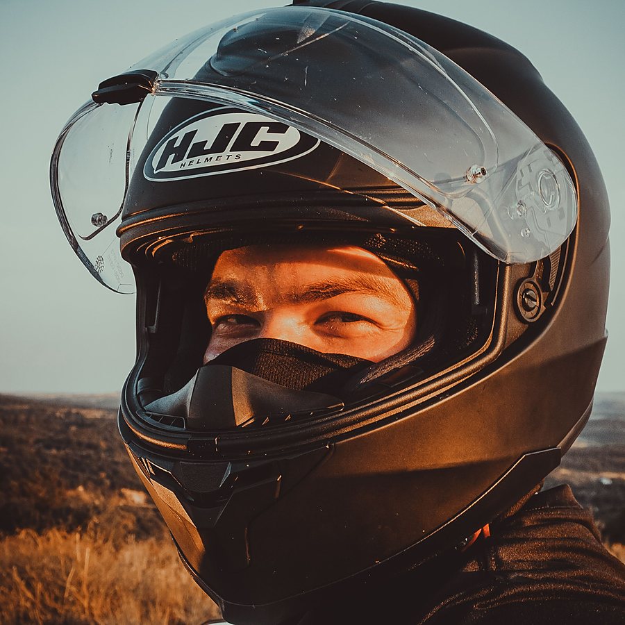 Motard casqué au coucher du soleil